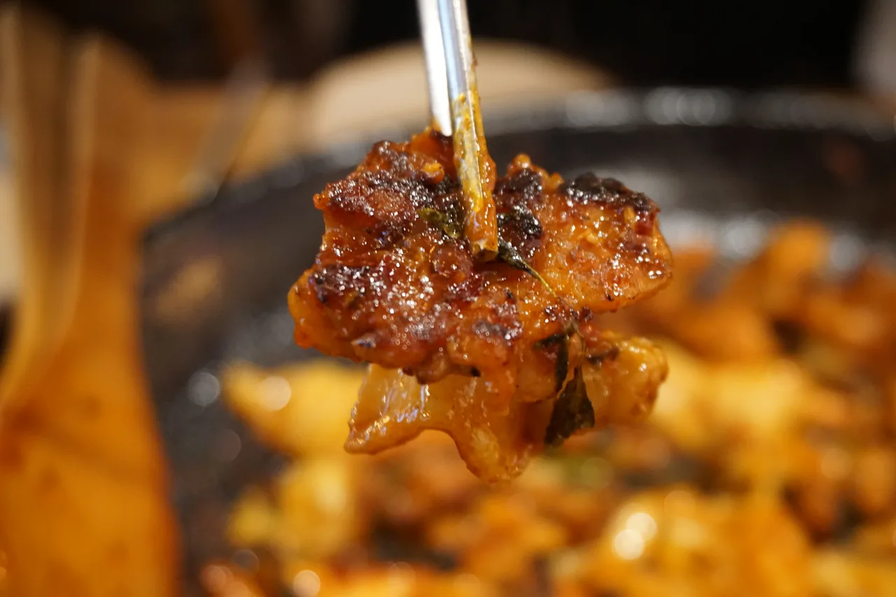 잘 익은 직화 닭갈비를 집어 든 모습